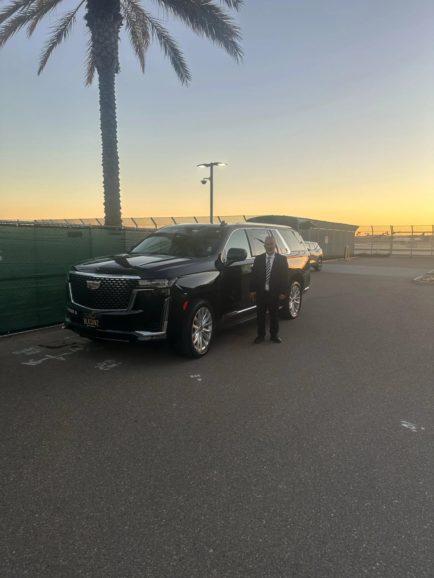 Chauffeur with the Cadillac Escalade at sunset
